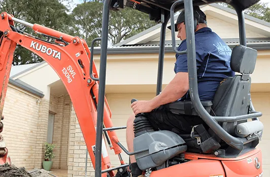 Mini excavator digging a trench for a pipe repair