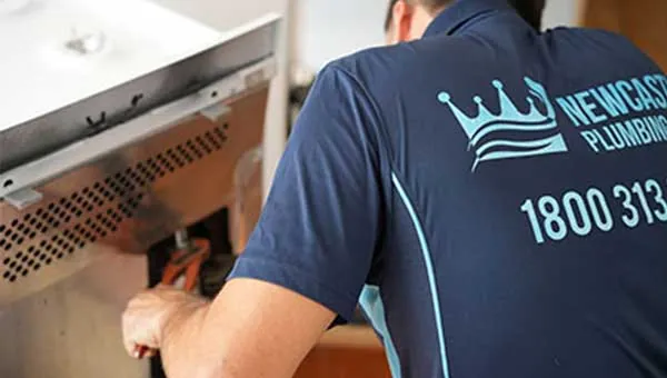 Gas fitter at work on a kitchen oven
